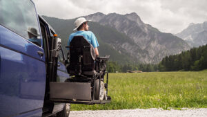 electric lift specialized vehicle for people with disabilities. Empty wheelchair on a ramp with nature and mountains in the back